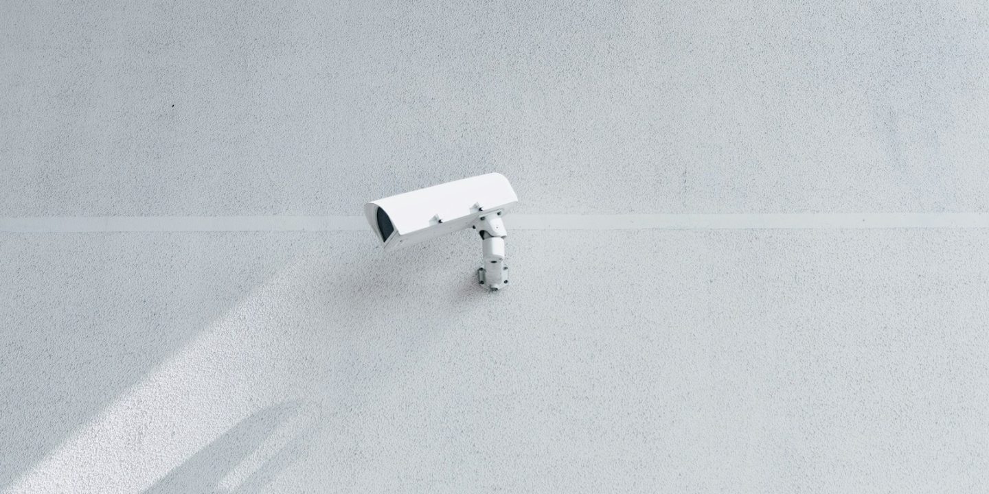 white box security camera on wall